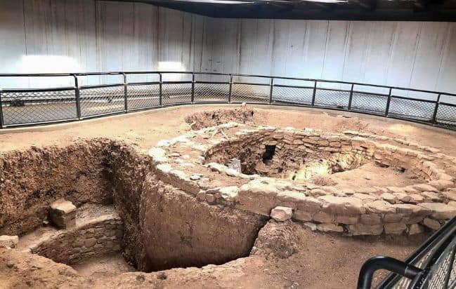 Pit House, archaeological site with circular stone structure and protective railing Mesa Verde National Park.