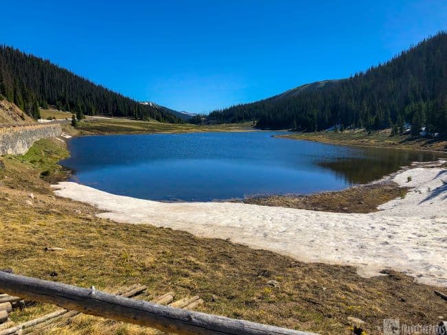 A picturesque Poudre lake in the Rocky Mountain National Park, framed by snow-dusted terrain and towering mountain peaks near Milners-Pass on the Trail Ridge Road