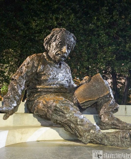 National Academy of Sciences-Bronze statue of a seated Albert Einstein figure holding a book on a circular stone platform.