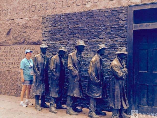 Bronze sculpture of five figures in a line against a brick wall. A woman join them in line at the Franklin Delano Roosevelt Memorial symbolizing the depression era.