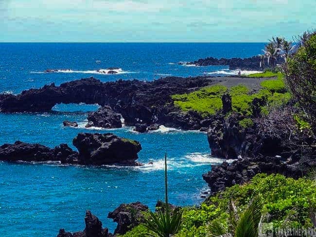 Sea Arch Maui Coastline-Rocky coastline with blue ocean and green vegetation.