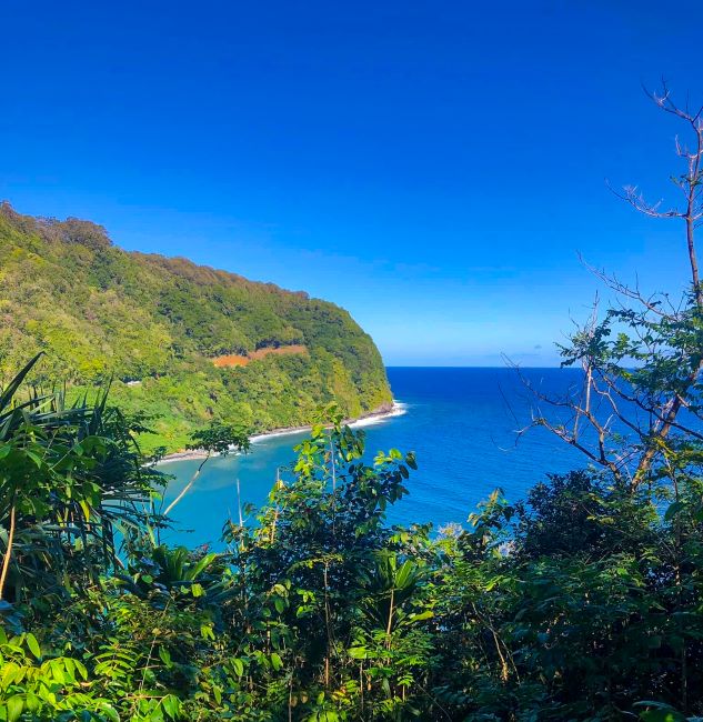 Honomanu Lookout: Scenic coastal view with a blue ocean and green hillside on the Road to Hana.
