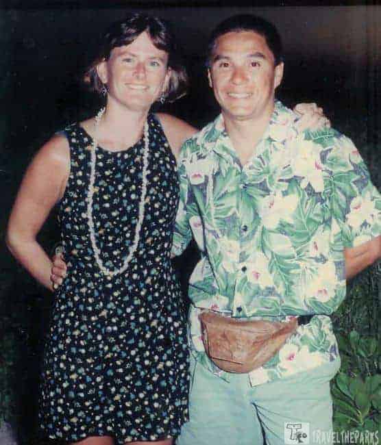 Maui Luau-Royal Lahaina: Two people smiling, wearing floral clothing with a dark background.

