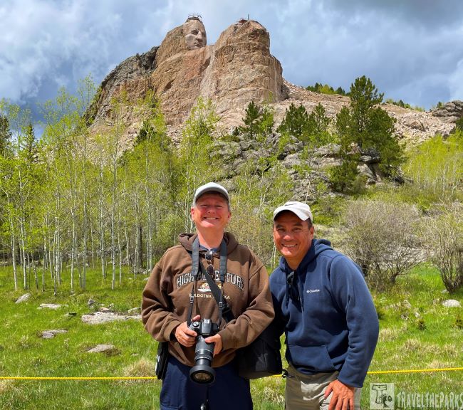 Crazy Horse Memorial with two people in the foreground smiling.