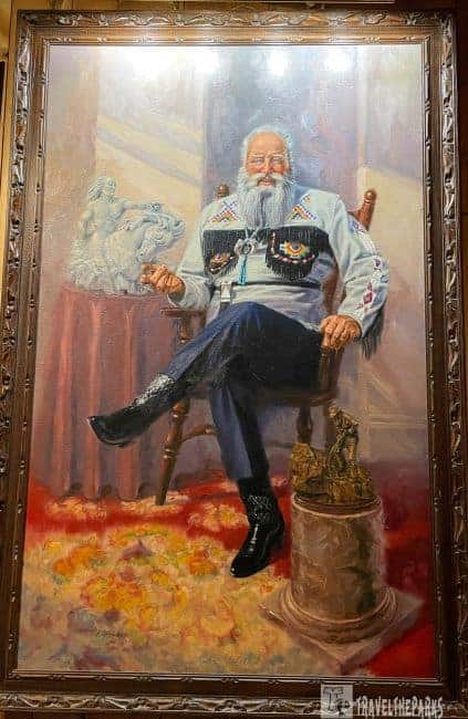 Crazy Horse Memorial
Painting of an Ziolkowski with a white beard seated in a chair, wearing a beaded shirt and boots, with sculptures nearby.