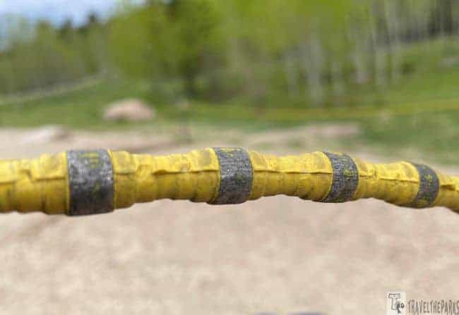 Close-up of a yellow diamond cutter wire with grey segments in a natural setting.
