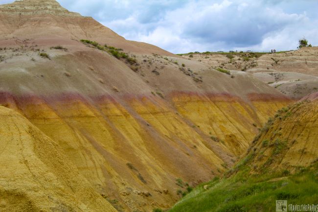 Yellow Mounds Overlook-Colorful stratified hills in Badlands National Park under a cloudy sky.