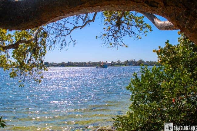 Manatee River DeSoto National Memorial-Coastal scene with shallow water, rocks, and mangrove trees under a blue sky with clouds.