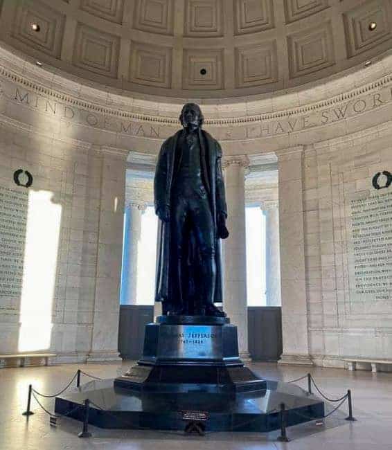 Thomas Jefferson bronze statue inside a domed rotunda with engraved walls and columns.