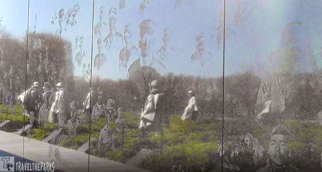 Korean War Veterans Memorial with soldier statues and reflective wall etched with faces.