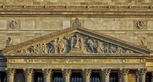 Recorder of the Archive-Facade of the National Archives Building with a sculpted pediment and Corinthian columns.