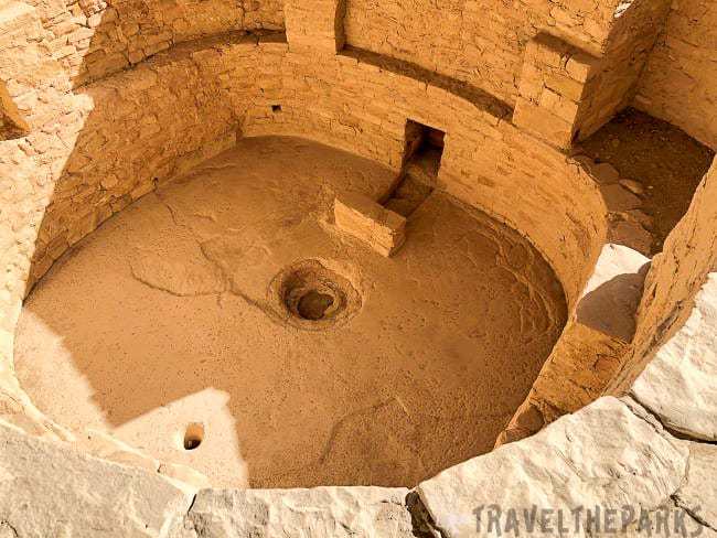 Ancient circular stone kiva structure viewed from above with a central depression and high sandstone walls at Balcony House