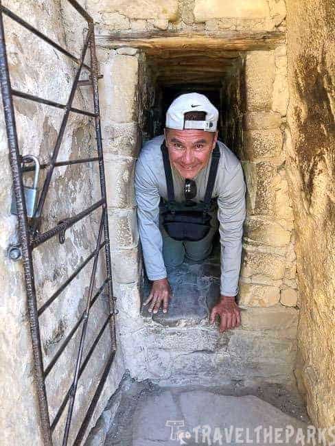 Man crawling through the tunnel at Balcony House in Mesa Verde National Park